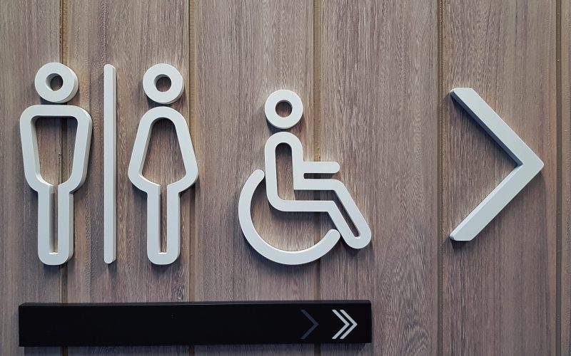 White Toilet Symbols on Wooden Plank Wall White Toilet Symbols on Wooden Plank Wall